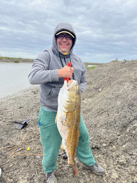 Andrew Landry, founder of Geaux Fish, holding a bull redfish on the Louisiana marsh